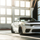 A photo of a white Dodge muscle car parked in a hanger